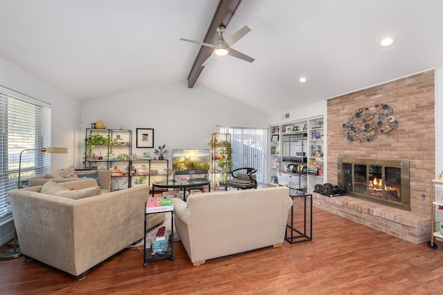 living room with a fireplace, hardwood / wood-style floors, vaulted ceiling with beams, and ceiling fan