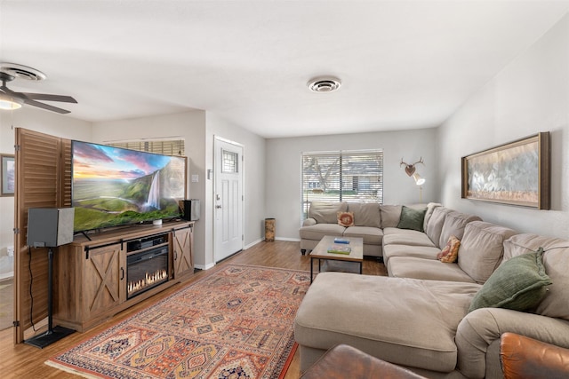 living room featuring ceiling fan and light wood-type flooring