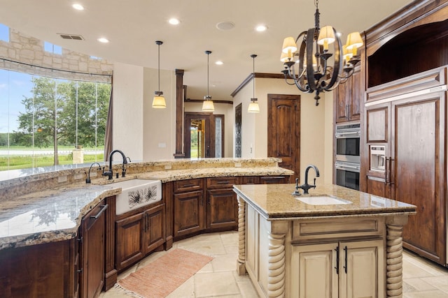 kitchen with pendant lighting, a notable chandelier, a large island, and sink