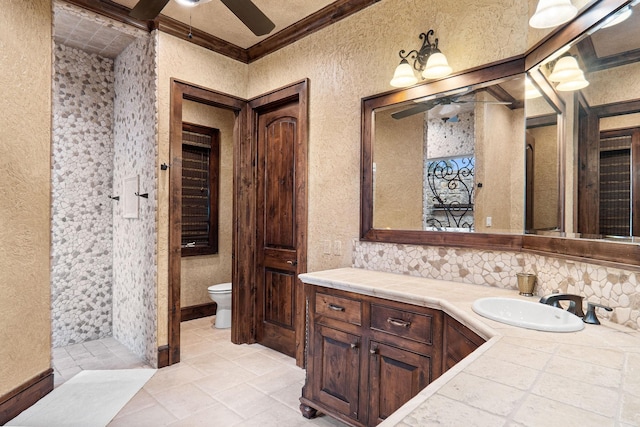 bathroom featuring vanity, toilet, crown molding, and walk in shower