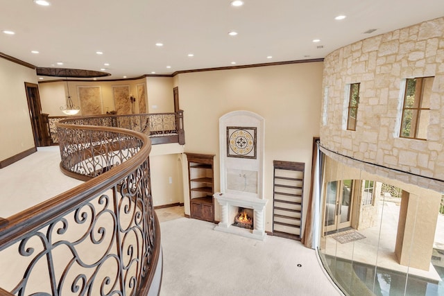 corridor featuring light colored carpet, crown molding, and a high ceiling