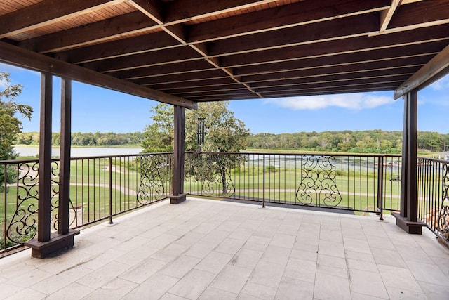 view of patio featuring a water view and a balcony