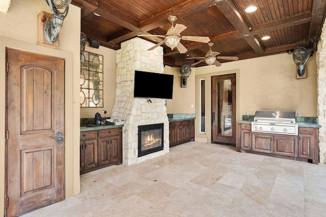 view of patio / terrace with a fireplace, area for grilling, ceiling fan, and a grill