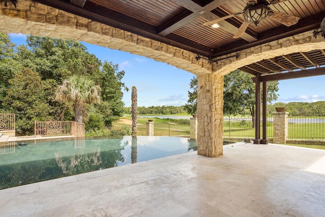 view of patio featuring ceiling fan, a fenced in pool, and a water view