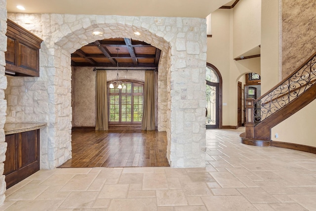 foyer with beam ceiling, light hardwood / wood-style floors, and coffered ceiling