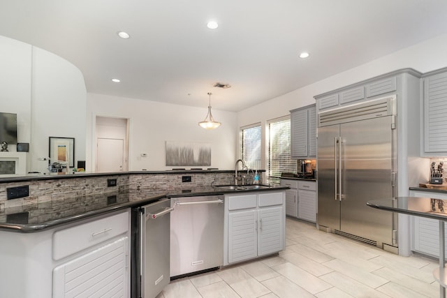 kitchen featuring sink, hanging light fixtures, tasteful backsplash, gray cabinets, and appliances with stainless steel finishes