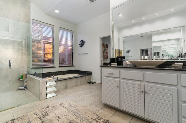 bathroom with tile patterned flooring, vanity, and separate shower and tub