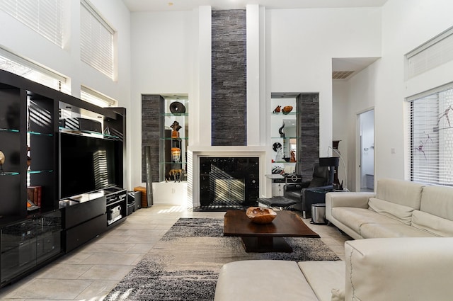 living room with a premium fireplace and a high ceiling