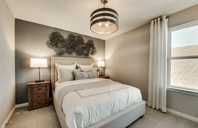 bedroom with light carpet and an inviting chandelier