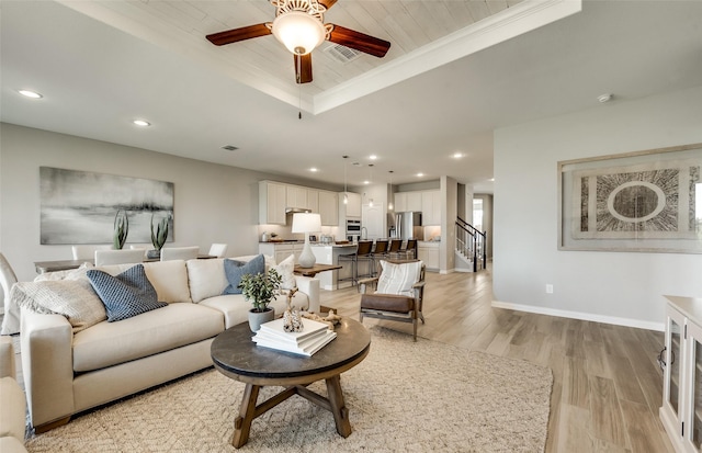 living room with a raised ceiling, ceiling fan, crown molding, wooden ceiling, and light hardwood / wood-style floors