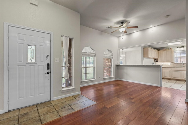 foyer entrance with hardwood / wood-style flooring, ceiling fan, and sink