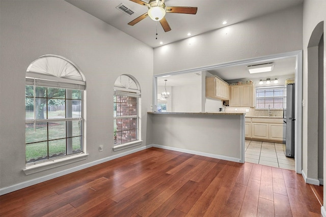 kitchen featuring cream cabinets, stainless steel fridge, light hardwood / wood-style floors, and sink