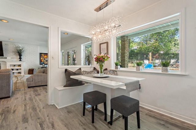 dining room featuring wood-type flooring, breakfast area, an inviting chandelier, and ornamental molding