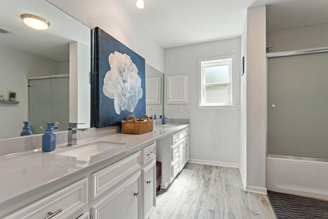 bathroom featuring hardwood / wood-style floors, vanity, and combined bath / shower with glass door