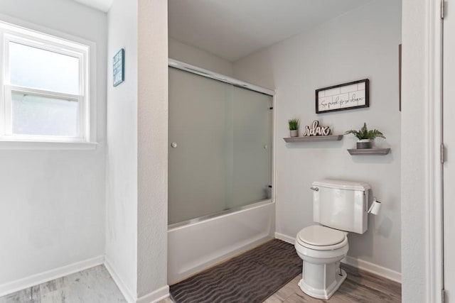 bathroom featuring toilet, combined bath / shower with glass door, and wood-type flooring