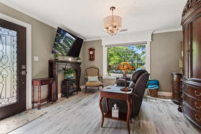 sitting room featuring an inviting chandelier, ornamental molding, and light wood-type flooring