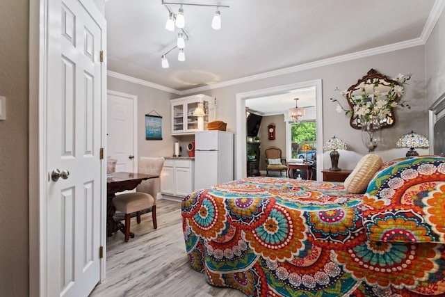 bedroom featuring light hardwood / wood-style floors, a chandelier, ornamental molding, and white refrigerator