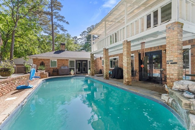 view of swimming pool featuring french doors and a grill