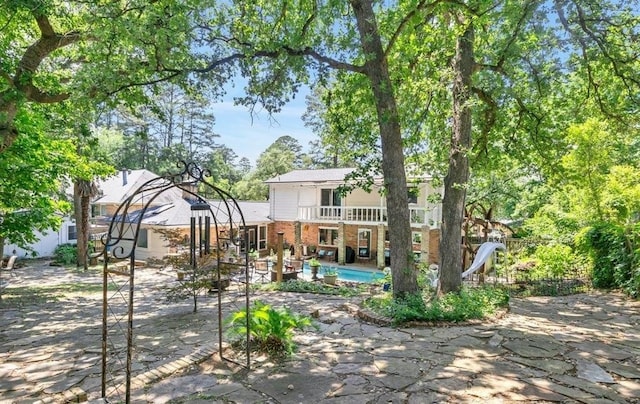 back of property featuring a balcony and a patio