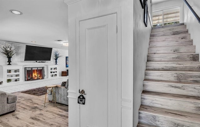 staircase featuring a fireplace and hardwood / wood-style floors