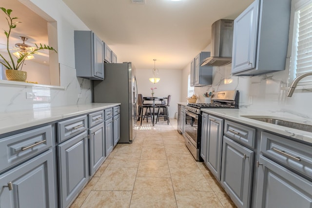 kitchen featuring gray cabinetry, wall chimney exhaust hood, sink, and appliances with stainless steel finishes