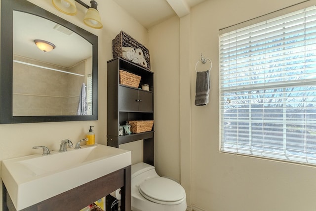 bathroom featuring vanity, toilet, and walk in shower