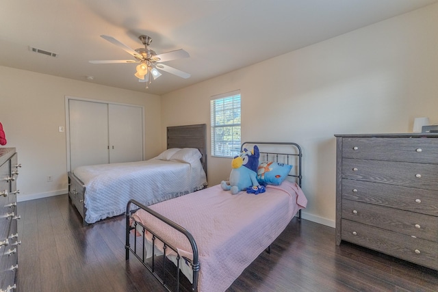 bedroom with ceiling fan, dark wood-type flooring, and a closet