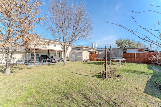 view of yard with a trampoline and a patio area