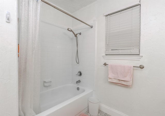 bathroom with a textured ceiling and shower / tub combo