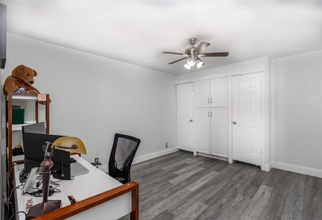 unfurnished office featuring a textured ceiling, ceiling fan, and dark wood-type flooring