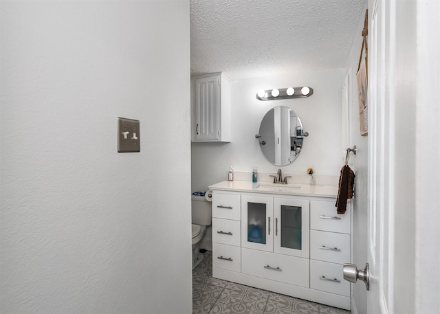 bathroom with tile patterned floors, vanity, toilet, and a textured ceiling