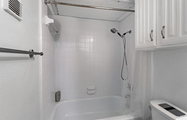 bathroom with toilet and tiled shower / bath