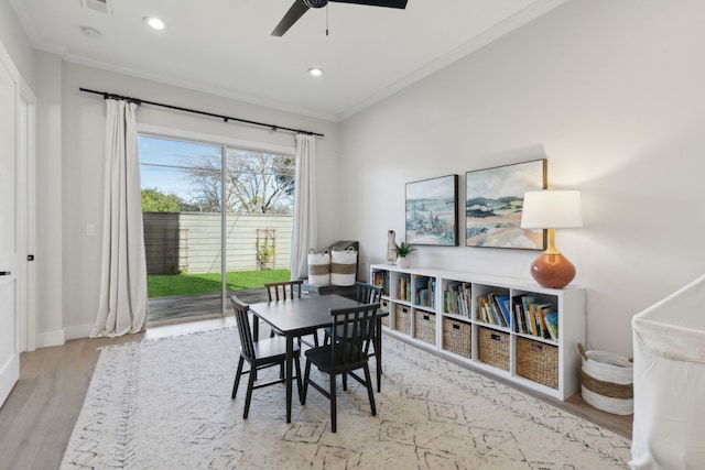 dining space with ceiling fan, light hardwood / wood-style floors, and ornamental molding