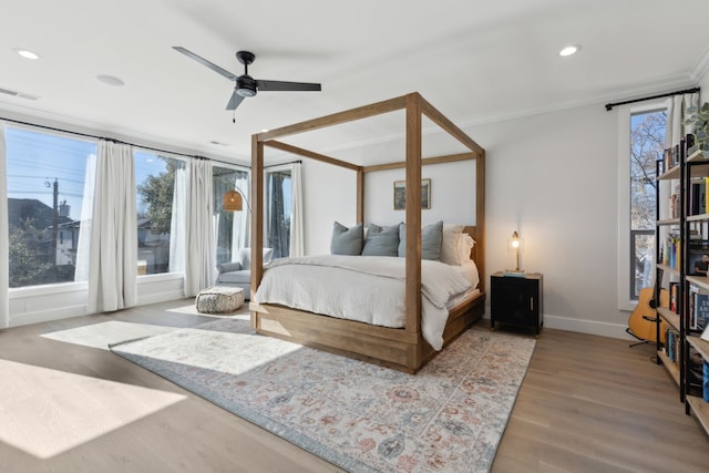 bedroom featuring ceiling fan, ornamental molding, and light wood-type flooring