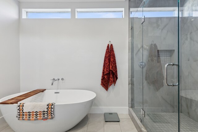 bathroom featuring tile patterned floors, a wealth of natural light, and separate shower and tub