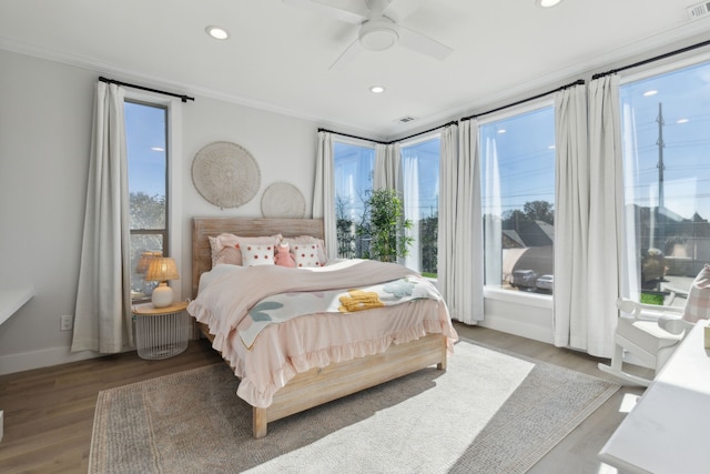 bedroom with ceiling fan, hardwood / wood-style floors, and ornamental molding