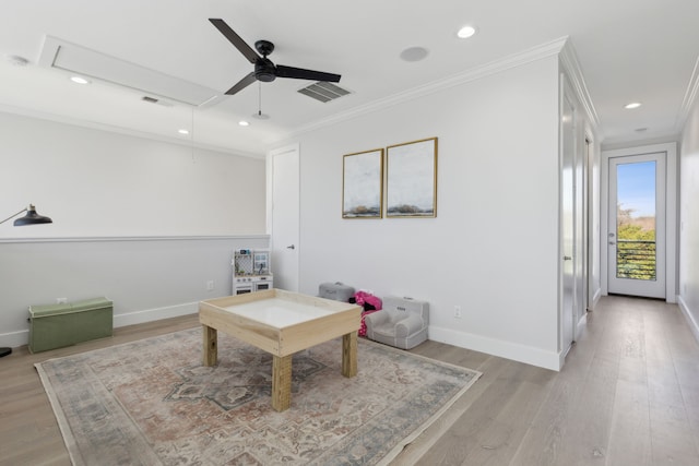 living area with ceiling fan, light wood-type flooring, and ornamental molding