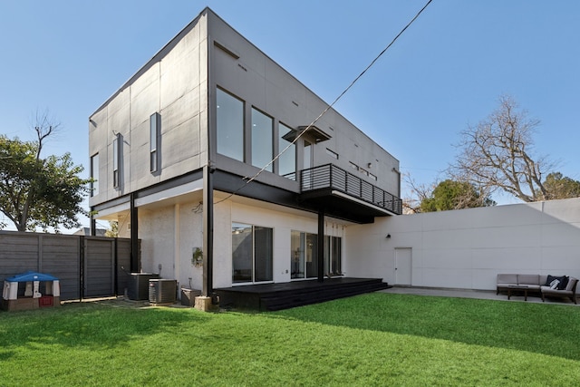 rear view of house with a lawn, outdoor lounge area, a patio area, and a balcony