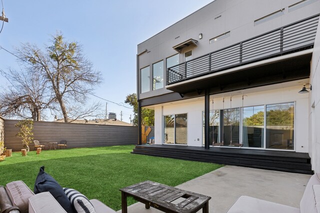 back of property featuring a lawn, outdoor lounge area, a balcony, and a patio