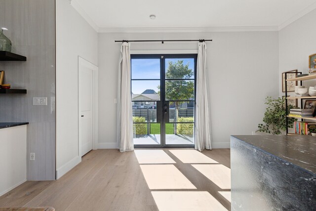 entryway featuring crown molding and light wood-type flooring