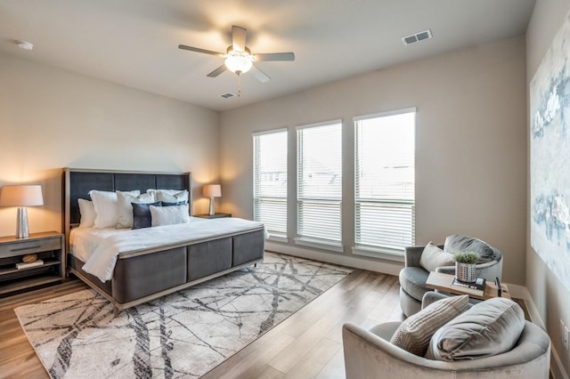 bedroom featuring a ceiling fan, wood finished floors, and visible vents