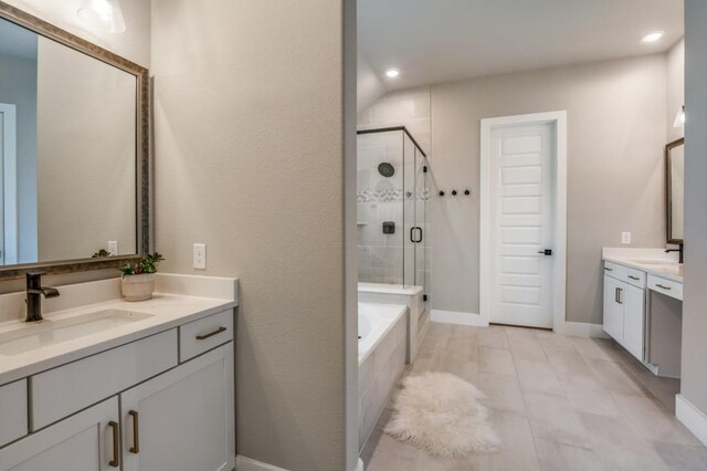 full bathroom with a sink, a garden tub, two vanities, and a shower stall