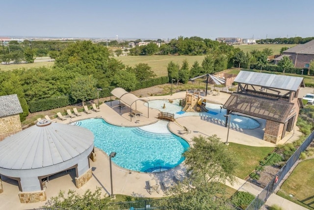 community pool with a patio and fence