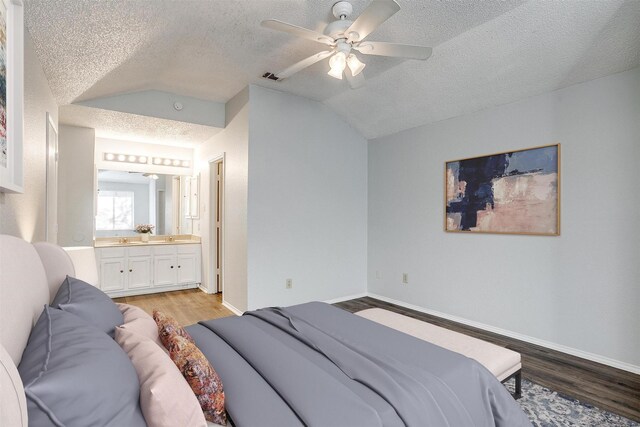 bedroom with ensuite bath, ceiling fan, lofted ceiling, and light wood-type flooring