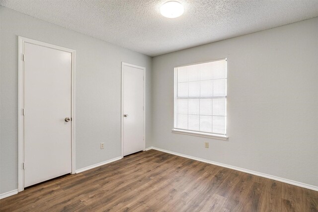 unfurnished bedroom featuring dark hardwood / wood-style floors and a textured ceiling