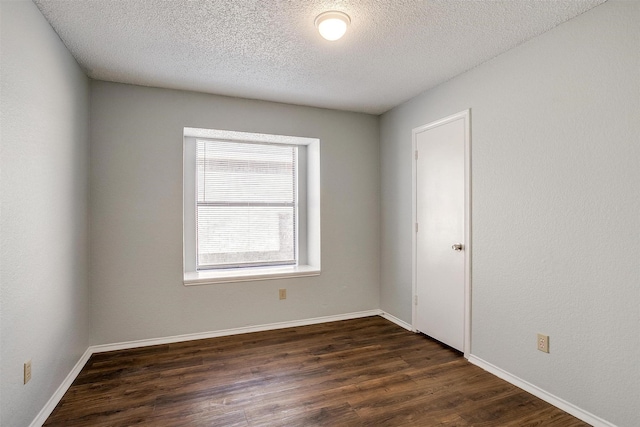 spare room with dark wood-type flooring and a textured ceiling