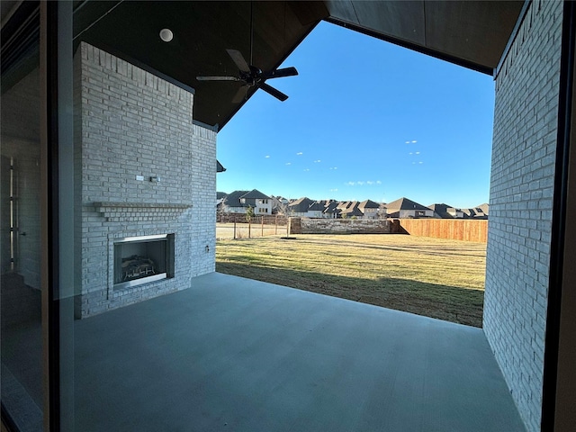 view of patio with an outdoor brick fireplace and ceiling fan