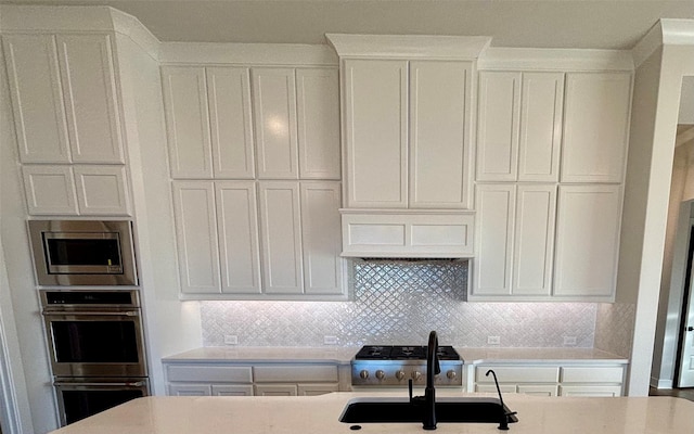 kitchen featuring white cabinetry, premium range hood, and appliances with stainless steel finishes