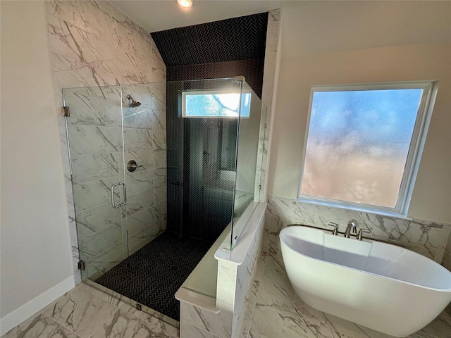 bathroom with shower with separate bathtub and tile walls