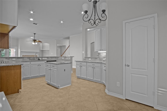 kitchen featuring white cabinetry, a center island, and decorative light fixtures